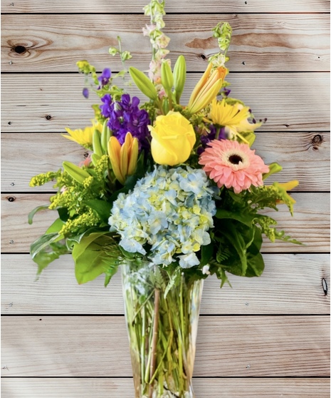 Bouquet of lilies, gerbera daisies, roses, hydrangea, snapdragons and more in a clear glass vase